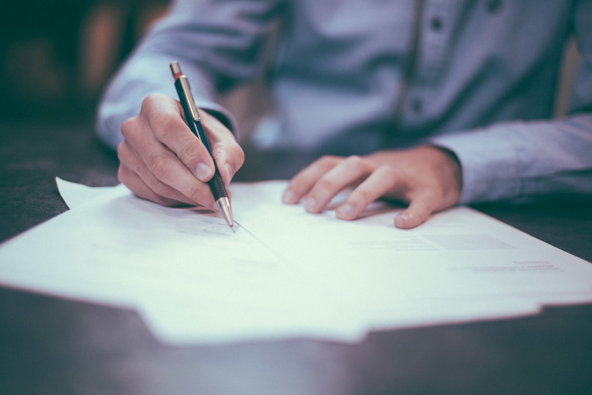 Close-up of a business owner reviewing and signing an SEO service contract