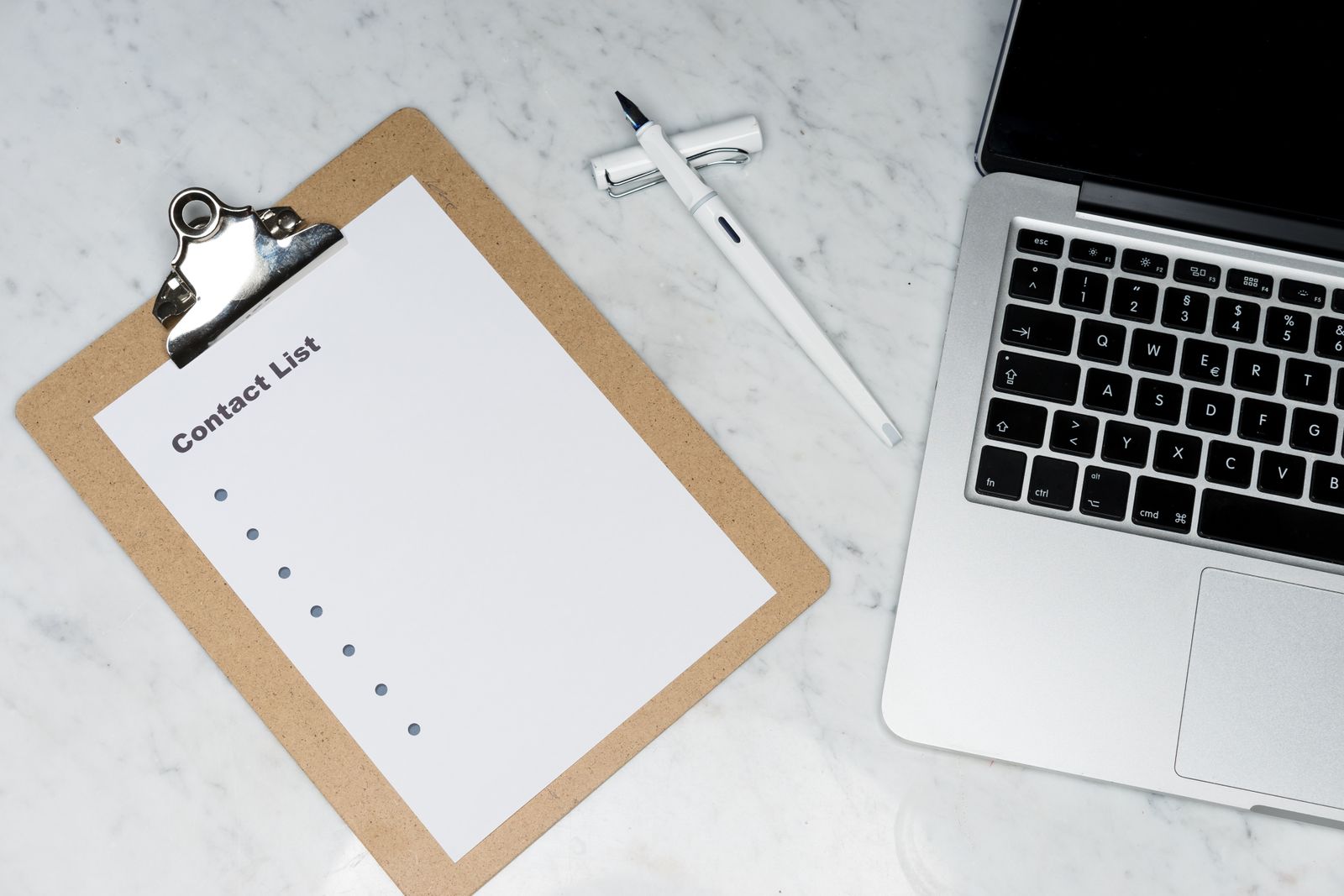 A Contact List clipboard next to a laptop, representing NAP data used across business directories